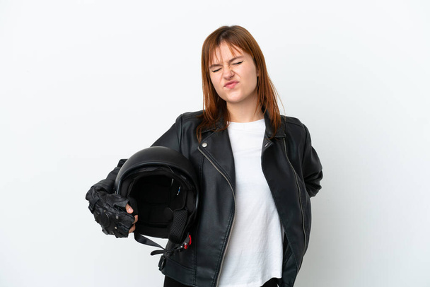 Menina ruiva com um capacete de motocicleta isolado no fundo branco sofrendo de dor nas costas por ter feito um esforço - Foto, Imagem
