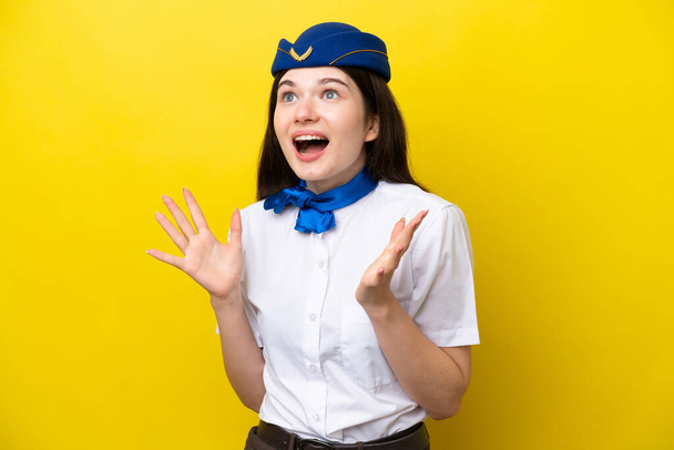 Airplane stewardess Russian woman isolated on yellow background with surprise facial expression - Photo, image