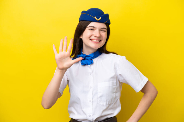 стюардеса літака російська жінка ізольована на жовтому фоні, рахуючи п'ять пальців. - Фото, зображення