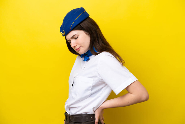 Airplane stewardess Russian woman isolated on yellow background suffering from backache for having made an effort - Foto, immagini