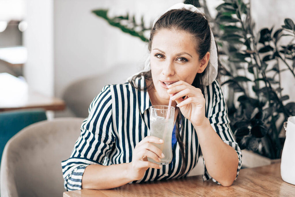 Portrait of a woman in a cafe, drinking juice - Fotografie, Obrázek