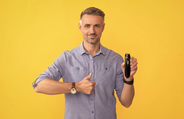 haircare and shaving. personal care and skincare. mens beauty. barbershop. man holding electric shaver. grizzled guy presenting electric razor. tumb up. - Foto, immagini