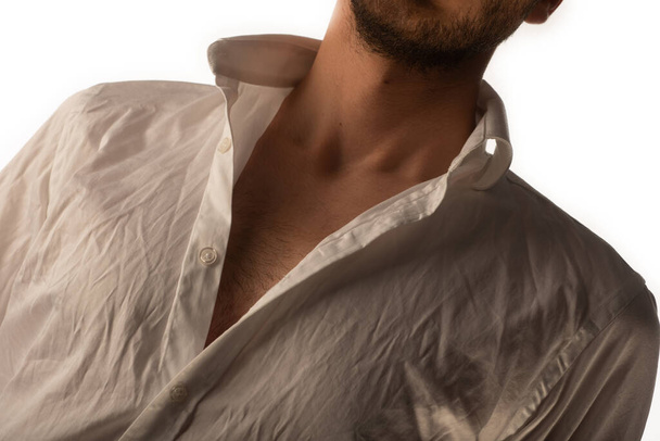 Yakışıklı bir adam stüdyoda fotoşopla gömleğini çıkarıyor. - Fotoğraf, Görsel