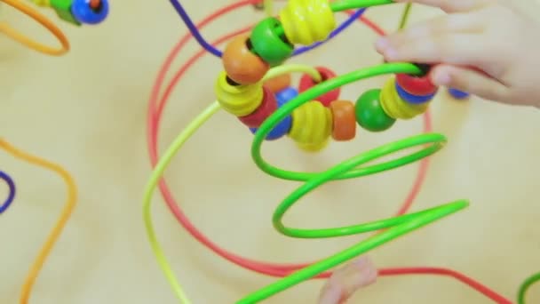 Kids Hands Playing Wooden Wire Maze Educational Game Toy toddler blocks. A game for the development of logic and fine motor skills of hands. Close-up. Selective focus - Footage, Video