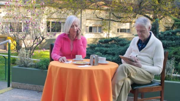 Пожилая пара готовит завтрак на открытом воздухе. - Кадры, видео