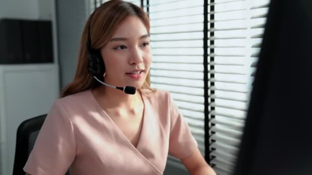 Competent female operator working on computer and while talking with clients. Concept relevant to both call centers and customer service offices. - Video