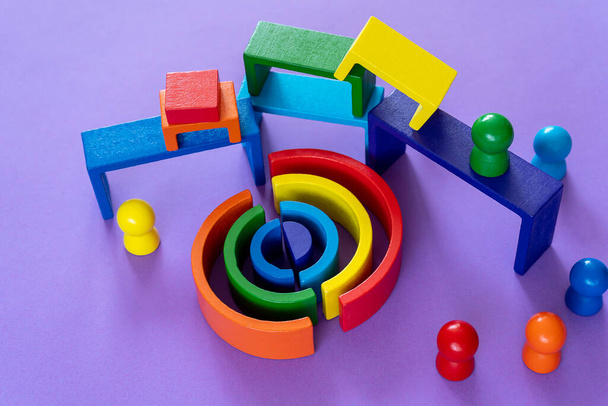 Sfondo arcobaleno astratto multicolore. Giocattoli per bambini in legno su carta viola. Blocchi di giocattoli educativi, arcobaleno. Giocattoli per l'asilo, la scuola materna o l'asilo nido. - Foto, immagini