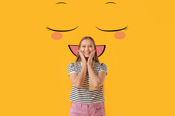 Happy young woman and drawn smile on yellow background - Photo, Image