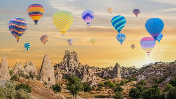 Kapadokya 'da güneş doğarken Goreme Açık Hava Müzesi üzerinde uçan sıcak hava balonu manzarası - Fotoğraf, Görsel