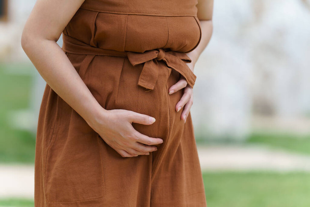 primo piano pancia della donna incinta ha mal di stomaco nel parco - Foto, immagini