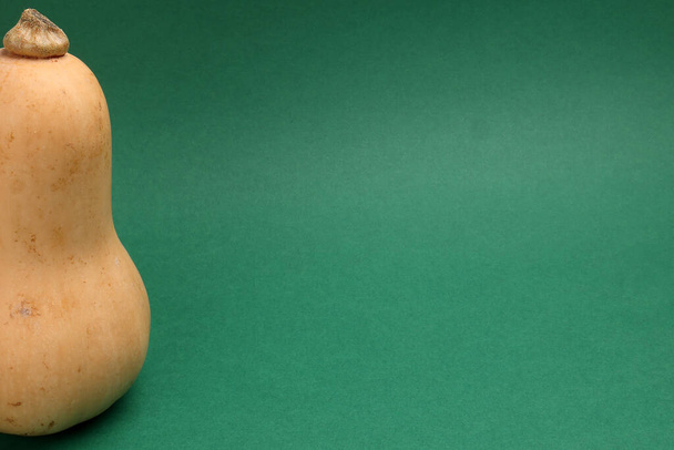 Yellow fresh ripe butternut squash on green background  - Zdjęcie, obraz