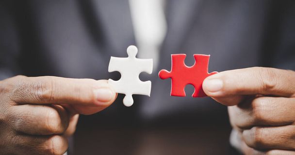 Business woman person hand holding puzzle piece idea for strategy and solution. Closeup part of two white jigsaw connect together. Concept of join cooperation success teamwork-problem corporate team - Φωτογραφία, εικόνα
