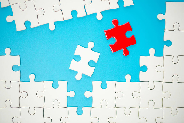 White part of jigsaw puzzle pieces on blue background. concepts of problem solving, business success, teamwork, Team playing jigsaw game incomplete, Texture photo with copy space for text - Foto, Bild