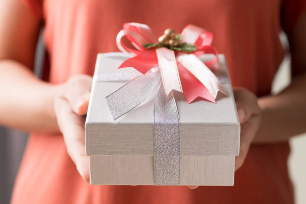 Silver gift box with ribbon in hand, Present for giving in special day and holiday - Φωτογραφία, εικόνα