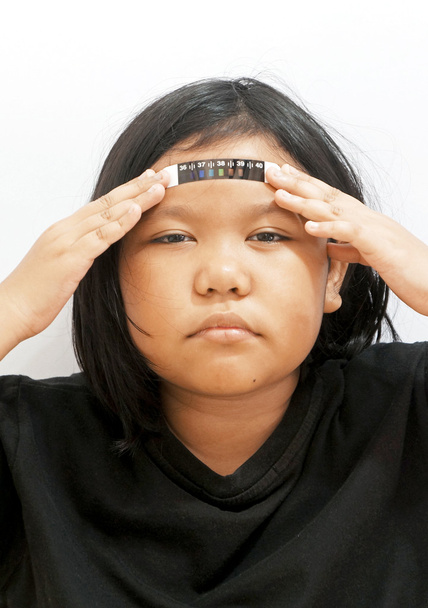 Sick little girl holding thermometer pad on forehead - Photo, Image