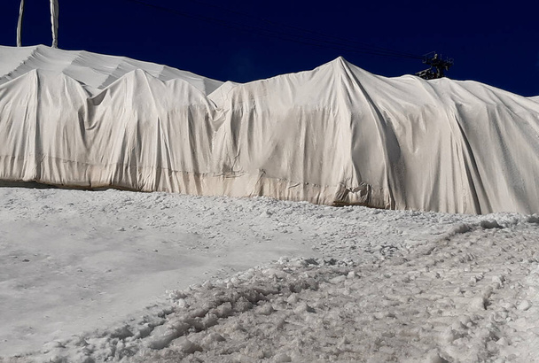 Buzulun 10 metre derinliğinde bile dev çatlaklar var. Buzların erimesi dağ kayak merkezlerinde sorunlara neden olur. Buz beyaz bir kumaşla kaplıdır, böylece asansörler çalışabilir. - Fotoğraf, Görsel