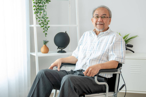 Портрет задоволеного літнього чоловіка, який сидить на інвалідному візку вдома. Старша особа в обслуговуванні будинку престарілих
 . - Фото, зображення