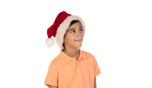 Sonriente niño feliz en sombrero de santa aislado sobre un fondo blanco - Foto, Imagen