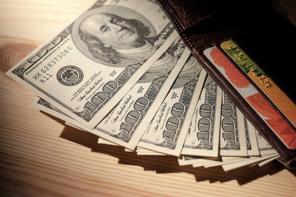 Brązowy portfel z kart kredytowych i banknotów dolara na drewniane  - Zdjęcie, obraz