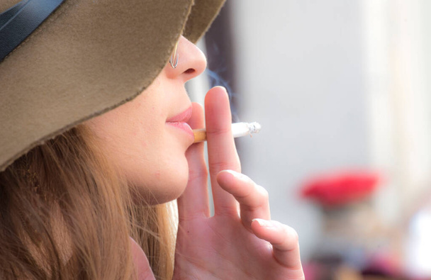 μια γυναίκα που καπνίζει τσιγάρο, μια γυναίκα με εθισμό στη νικοτίνη - Φωτογραφία, εικόνα