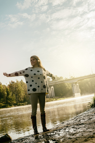 lonely happy beautiful girl walks on river bank early in morning - Foto, Imagem