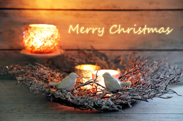 Χριστούγεννα στεφάνι με κεριά και διακοσμητικά πτηνά στο ξύλινο τραπέζι - Φωτογραφία, εικόνα