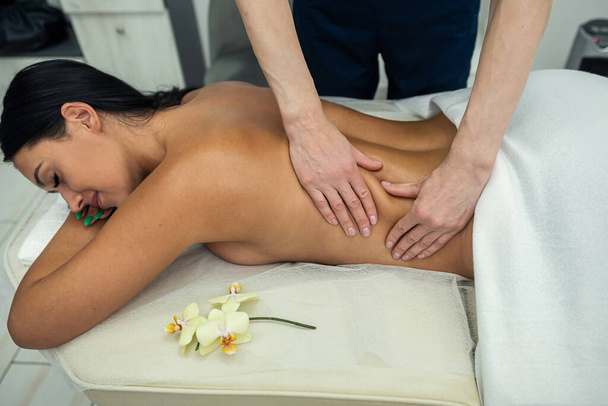 закрытие женских рук, делающих отдых и лечебный массаж шеи для молодой женщины в спа. Лечение - Фото, изображение