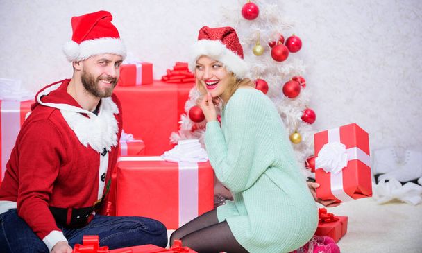 Loving couple cuddle smiling while unpacking gift christmas tree background. Opening christmas present. Family prepared christmas surprise. Couple in love happy enjoy christmas holiday celebration. - Фото, зображення