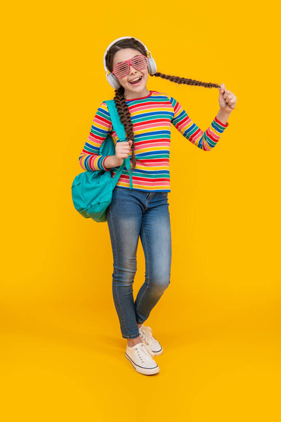 Music education. Girl teenager singing along to music after school yellow background, music. - Φωτογραφία, εικόνα