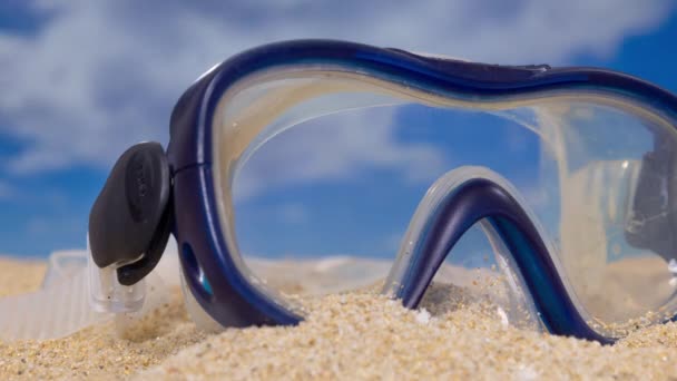 Una maschera da snorkeling sulla spiaggia con nuvole di passaggio  - Filmati, video