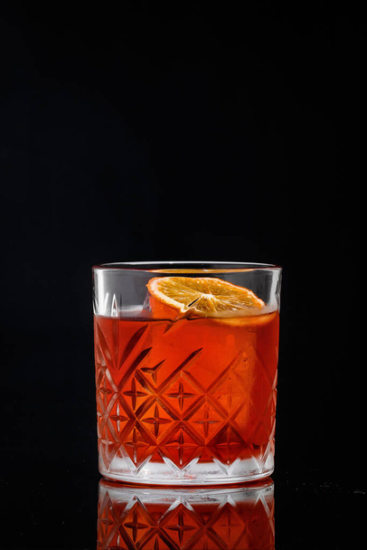 fresh cold cocktail with whiskey ice cube orange chips on black background - Foto, Imagen