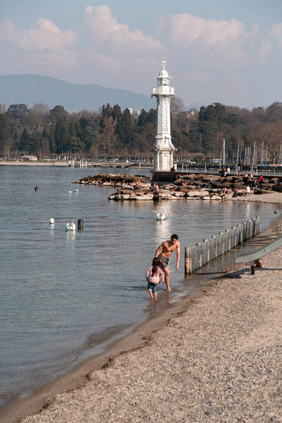 Geneva, Switzerland - 25 March 2022: People enjoying the scenic view of the Geneva Lake at the Bay of Geneva, the French section of Switzerland. - Φωτογραφία, εικόνα