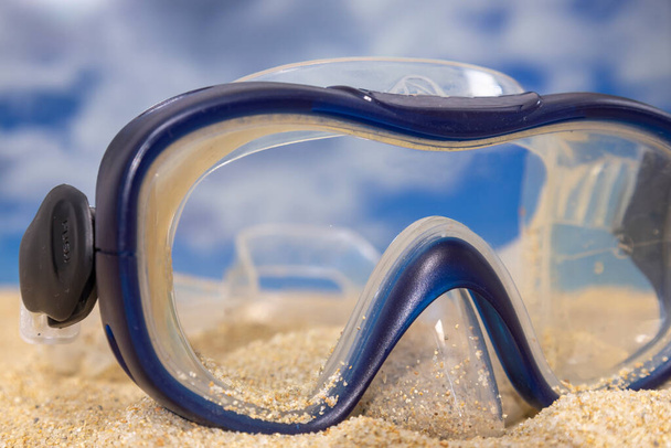 A snorkel mask on the beach with sea and sky in the background - Foto, Imagem