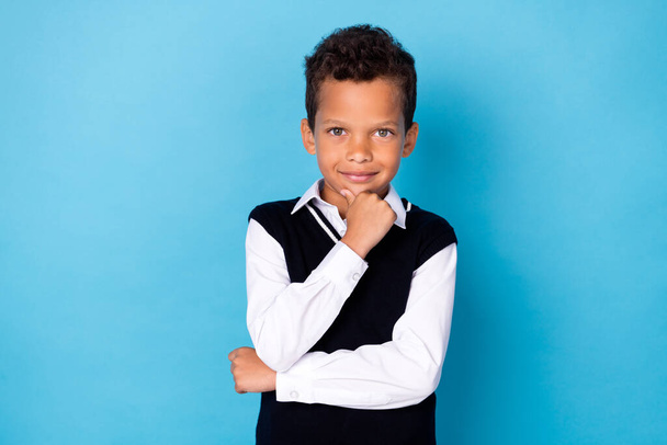 Photo of cute intelligent small boy wear black waistcoat smiling arm chin smiling isolated blue color background. - Foto, immagini