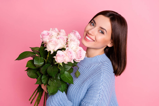 Profil Porträt der schönen netten Person halten Rosenblumen strahlendes Lächeln isoliert auf rosa Hintergrund. - Foto, Bild