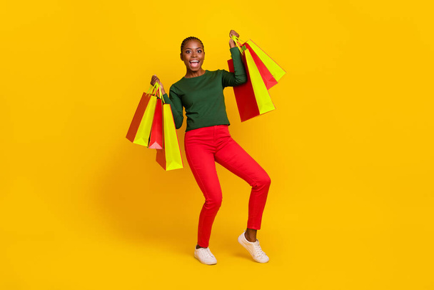 Full length photo of lucky pretty lady dressed green shirt rising bargains fists isolated yellow color background. - Φωτογραφία, εικόνα