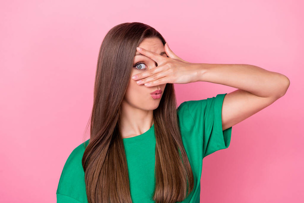 Photo of lovely nice gorgeous girl with straight hairstyle dressed green t-shirt look one eye spy isolated on pink color background. - Foto, imagen