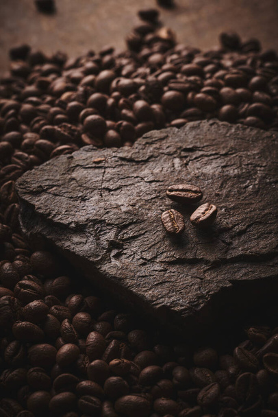 Roasted coffee beans on stone pedestal brown background - Fotoğraf, Görsel