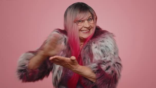 Щаслива багата стильна літня жінка, яка показує марнування або кидання грошей навколо жесту рук, більше порад, які мріють про великий прибуток мови тіла. Старша бабуся позує ізольовано на рожевому студійному фоні
 - Кадри, відео
