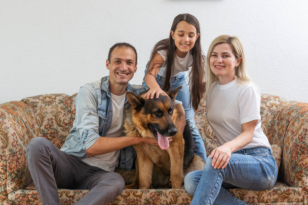 Portrait of happy family with a dog having fun together at home. - Fotografie, Obrázek