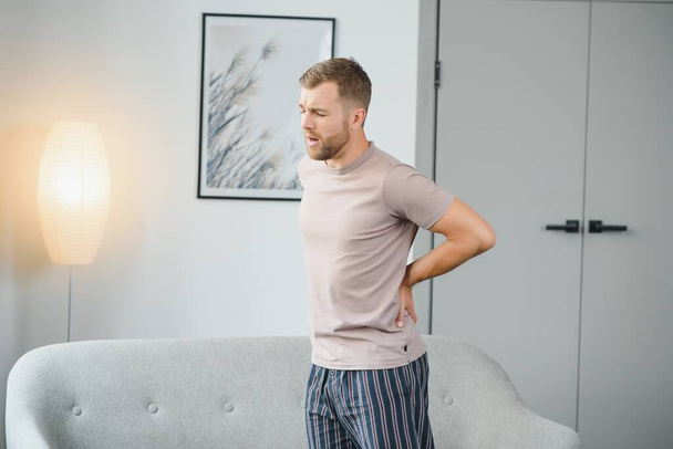 Back pain, kidney inflammation, man suffering from backache at home, health problems concept - Photo, image