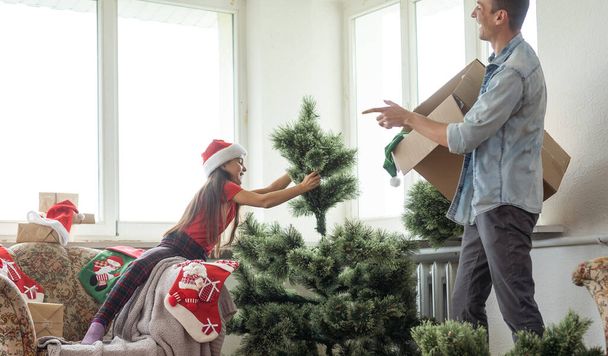 Father and little daughter decorating Christmas tree in room. - Photo, Image
