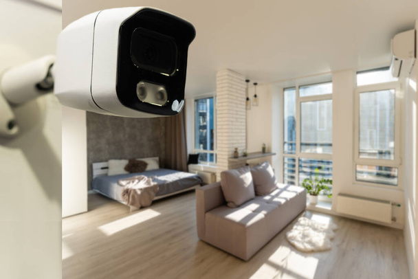 Close Up Oggetto girato di una moderna telecamera di sorveglianza Wi-Fi su un muro bianco in un accogliente appartamento ha l'icona Wi-Fi sopra di esso - Foto, immagini