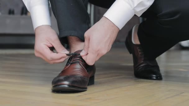 Großaufnahme eines Mannes, der seine Schnürsenkel bindet. Bräutigam morgens und Vorbereitung auf den Hochzeitstag - Filmmaterial, Video