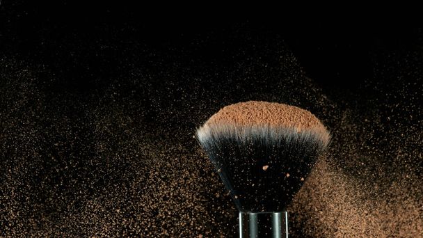 Brown makeup powder on brush. Isolated on black background. - Foto, imagen
