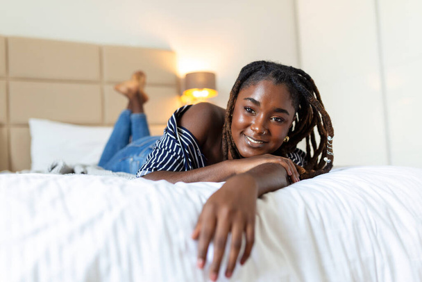 Muotokuva kaunis ja aistillinen muotokuva kaunis ja aistillinen Afrikkalainen nuori nainen makaa sängyssä. Kaunis nainen makaa sängyssä Afrikkalainen nuori nainen makaa sängyssä. - Valokuva, kuva