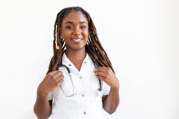 Confident smiling doctor posing and looking at camera with stethoscope in her hands. Friendly African American female doctor smiling. Doctor with stethoscope around her neck - Fotoğraf, Görsel