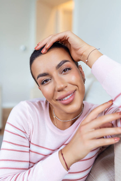 Portrait of a beautiful woman smiling at home. African American woman in casual looking at camera with copy space. Cheerful mixed race girl relaxing at home with big laugh. - Foto, immagini