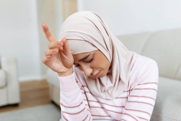 elegantní docela muslimské ženy pocit bolesti hlavy bolestivé posezení na rozkládací pohovce relaxační. - Fotografie, Obrázek