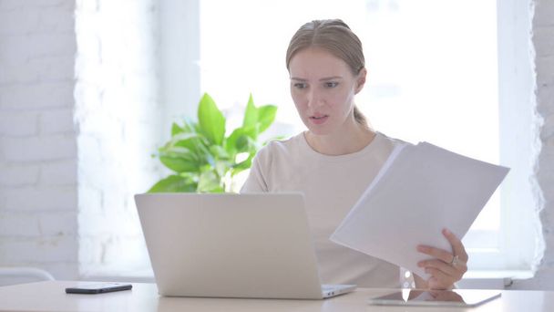 Young Woman Upset while Reading Business Report at Work - Foto, Imagen